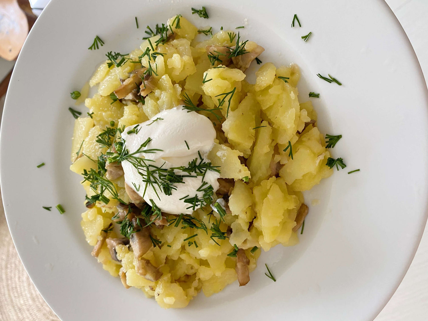 Fried potatoes and mushrooms in provencal butter with sour cream